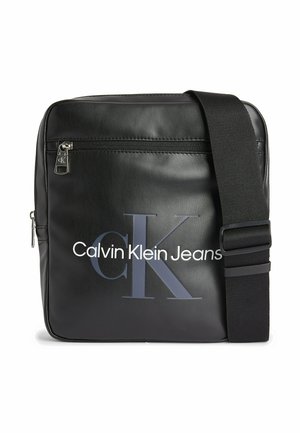 Black leather crossbody bag with adjustable strap, featuring a zippered closure and a large logo displaying "Calvin Klein Jeans" in contrasting colors.