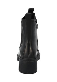 Botines de cuero negro con un acabado suave, cierre de cremallera y una lengüeta en la parte trasera. La suela es gruesa y texturizada para mayor agarre.