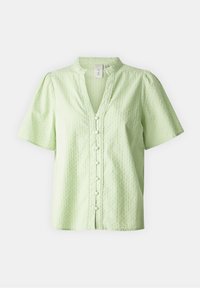 Blouse vert clair à manches courtes en tissu délicatement texturé, boutons recouverts de tissu sur le devant, et petit col montant avec bordure en dentelle.