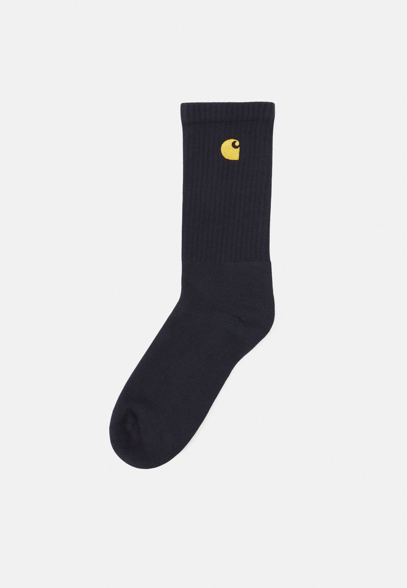 Marineblå ribbede sokker lavet af blødt stof, med et lille gult logo på siden. Klassisk design med en behagelig pasform.