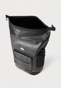 Svart vanntett bag med bred åpning, sidelomme og teksturert overflate. Har merkevarelogo på forsiden og justerbar stropp.