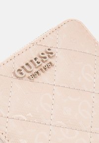 Light pink patent leather wallet with quilted pattern, embossed logo, and contrasting stitching detail. Features minimal hardware accents.