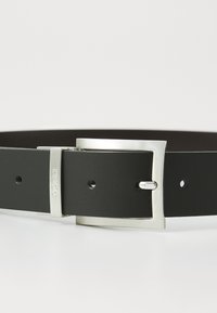 Cinturón de cuero negro con una hebilla rectangular de plata, que presenta un acento de logo y múltiples agujeros de ajuste. Textura suave y diseño clásico.