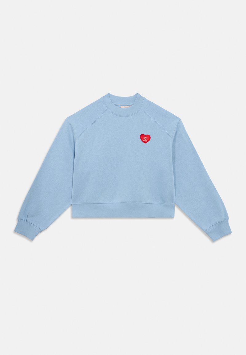 Ανοιχτό μπλε κοντή μπλούζα με μακριά μανίκια, ριμπ μανσέτες και τελείωμα, με μικρό κόκκινο μπάλωμα καρδιάς με λευκό κείμενο στο στήθος.