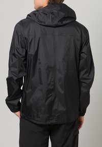 Chaqueta negra impermeable con capucha, hecha de un material sintético brillante. Cuenta con puños y dobladillo elásticos, con un diseño simple y minimalista.