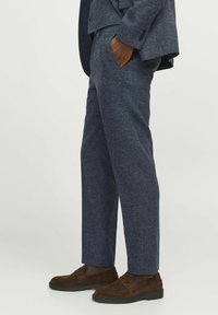 Dunkelblaue Wollmischungshosen mit strukturiertem Finish, geradem Schnitt und seitlichen Taschen, kombiniert mit dunkelbraunen Wildleder-Slippern.