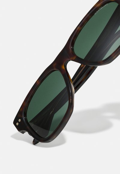 Skilpaddebriller med mørkegrønne linser. Tykk rammedesign og subtile gullaccentene på hengslene. Semi-matt overflatelag.