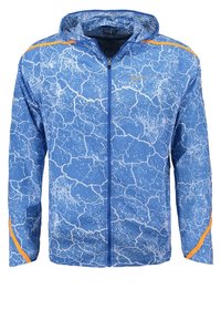 Veste à fermeture éclair bleue en matière légère avec un motif blanc craquelé et des accents orange aux épaules. Comprend une capuche et des poignets élastiques.
