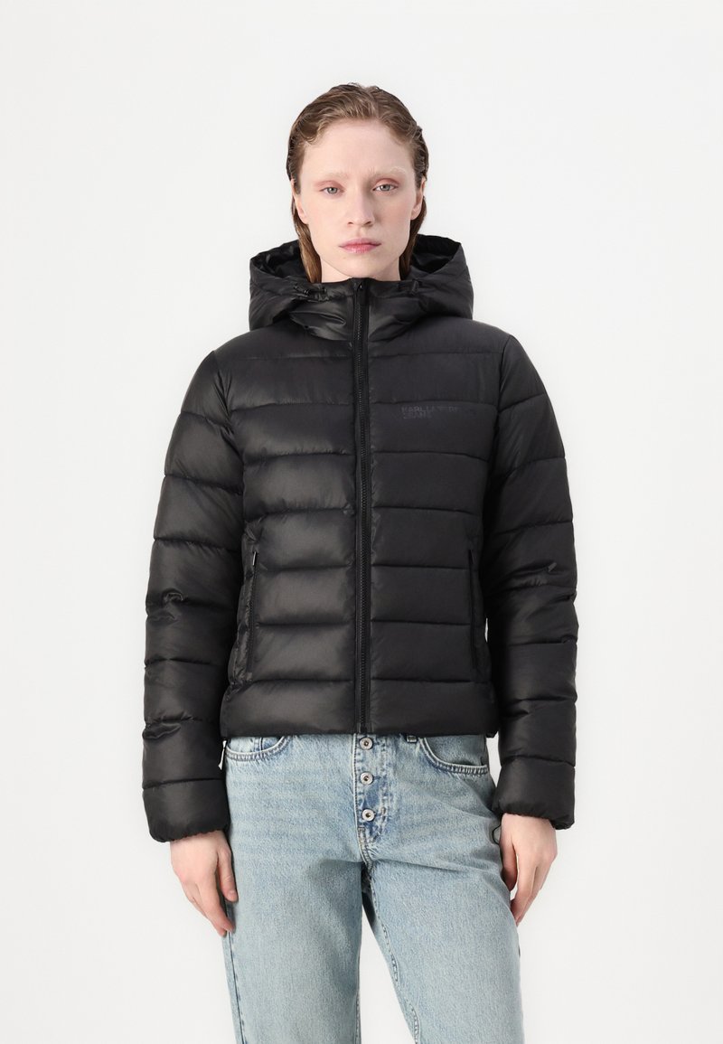 Svart puffjacka med huva, som har en vadderad design, framdragkedja och sidofickor. Slät yta och något reflekterande material.