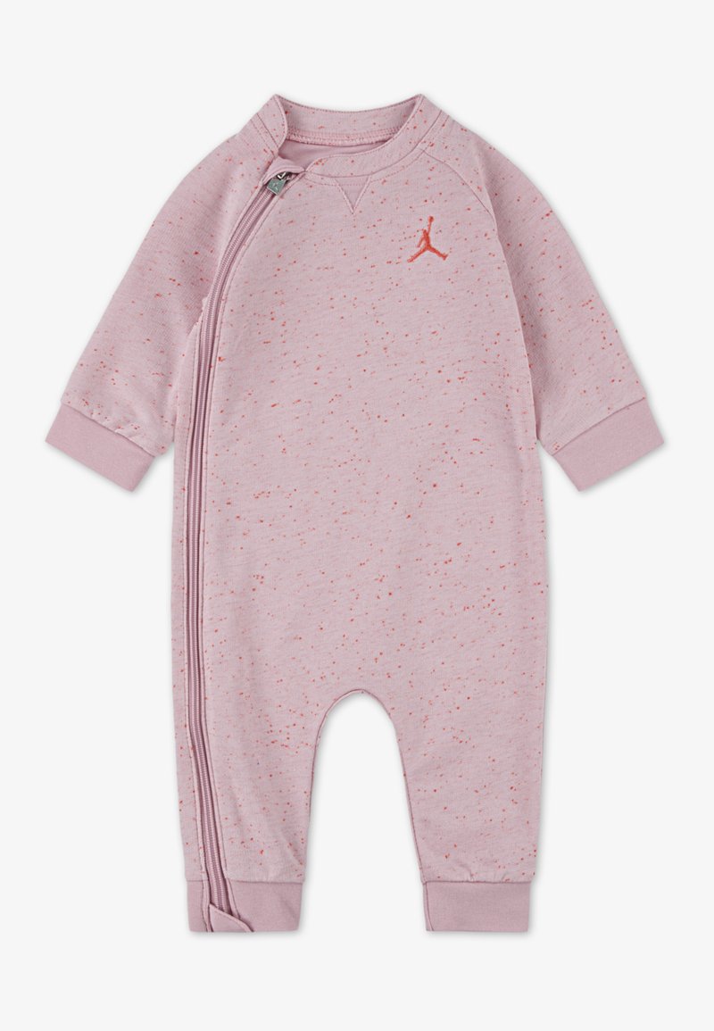 Lys rosa jumpsuit laget av mykt stoff, med glidelås foran, lange ermer og en liten rød logo detalj.