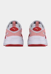 Κόκκινα και ροζ αθλητικά παπούτσια με επενδυμένο πλεκτό γιακά, τον έντονο λογότυπο της Puma και λευκές σόλες με κόκκινες λεπτομέρειες και υφασμένους μοτίβους.