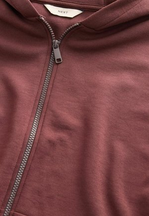 Bordowy rozpinany hoodie wykonany z miękkiego materiału. Posiada metalowy zamek błyskawiczny z plastikowym uchwytem oraz metkę z napisem "NEXT" wewnątrz kołnierza.