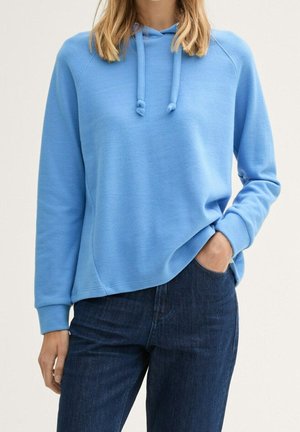 Lichtblauwe hoodie met een ontspannen pasvorm, trekkoordcapuchon en ribgebreide manchetten, gecombineerd met donkerdenim jeans. Gladde stofstructuur.