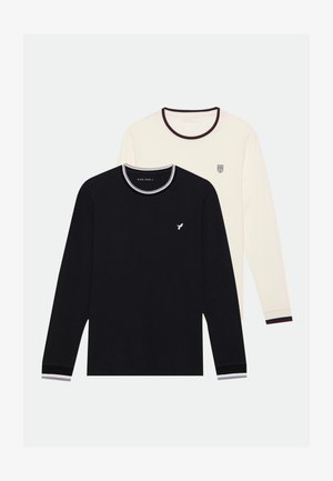 Two long-sleeve tops: one black with a crew neck and white accents, and one cream with a logo and contrasting ribbed hem.