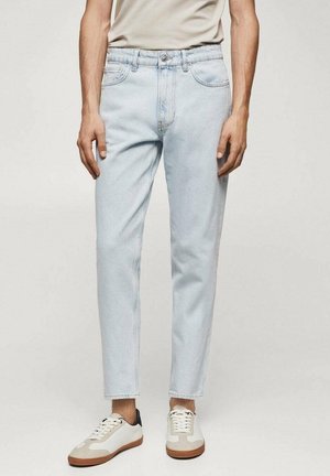 Lichtblauwe denim jeans met een rechte snit, vijf zakken, vervaagde wassing en een sluiting met een knoop aan de voorkant, gecombineerd met witte en crème sneakers.