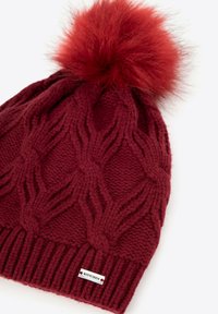 Bordowa dzianinowa czapka z warkoczowym wzorem i puszystym czerwonym pomponem na górze. Posiada ściągacz na dole z niewielką metką WITCZEN.