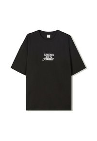 Svart bomull T-shirt med kort ärm som har vit stiliserad text "EN ANNAN DAG I PARADIS" på framsidan. Normal passform och rund hals.