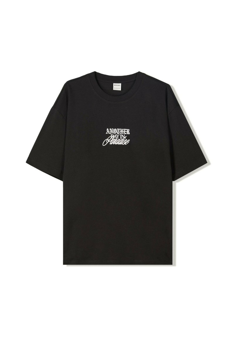 Svart bomull T-shirt med kort ärm som har vit stiliserad text "EN ANNAN DAG I PARADIS" på framsidan. Normal passform och rund hals.
