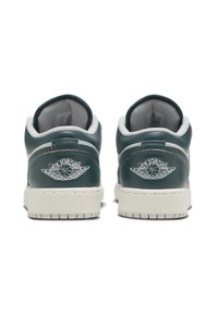 Grønne læder lavtoppede sneakers med hvid mesh-fór, teksturerede såler og et markant hvidt broderet logo på hælen. Klassiske design elementer.