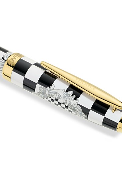 Peresnica z črno-belo kockastim vzorcem, z sijočo površino, z zlatimi dodatki in zapletenimi sivozlatimi vzorci; vključuje sponko za pritrditev.