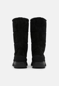 Botas de ante negras hasta media pantorrilla con un diseño acolchado. Parte superior de tela texturizada, suela de goma y un acento de logotipo en el talón trasero.