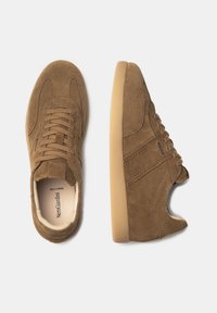 Sneaker in suede marrone con una finitura texture, caratterizzati da una punta rotonda, chiusura con lacci e una suola in gomma beige flessibile.