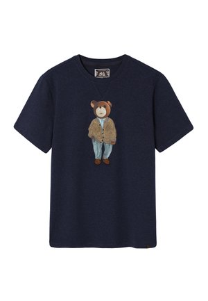 Laivastonsininen puuvillainen t-paita, jossa on kirjailtu karhu, joka pukeutuu pörröiseen ruskeaan takkiin ja vaaleansinisiiin housuihin, lyhyet hihat ja pyöreä pääntie.