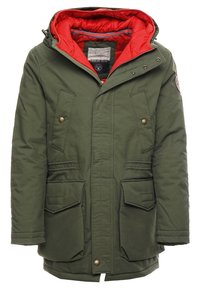Parka verde de invierno con forro de capucha acolchado rojo, cremallera frontal con botones de presión y cuatro bolsillos sobre un fondo blanco.