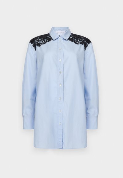 Jasnoniebieska koszula z długim rękawem, z czarnymi koronkowymi akcentami na ramionach i klasycznym kołnierzykiem. Gładki bawełniany materiał.