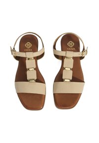Beige sandalen met een gestructureerde band, gouden hardware en een platte zool. Verstelbare enkelband met een vierkante teen ontwerp.