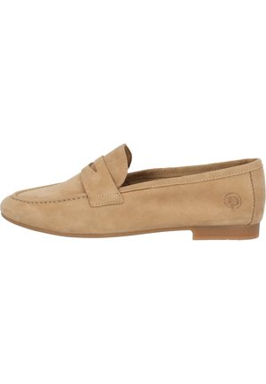 Tan suede loafers feature a flat sole, a stitched design, and a front strap detail. The heel is low with a logo on the outer side.