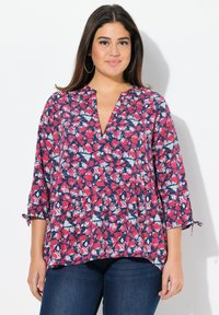 Bloemmotief top met rode, roze en witte bladeren op een marineblauwe achtergrond, met een V-hals en driekwart mouwen. Lichtgewicht, vloeiende ontwerp.