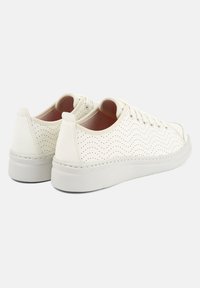 Sneakers bianchi perforati con tomaia in pelle liscia, punta arrotondata e suola in gomma. Presentano lacci piatti e un interno imbottito.