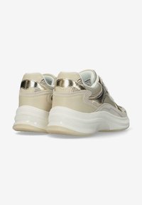 Sneaker mit einem metallisch goldenen Akzent, hellbeigen Elementen und einer dicken weißen Sohle. Strukturiertes Rückenteil und glatte Oberflächen.