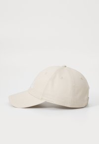 Cappellino da baseball in cotone beige con visiera curva, logo ricamato sul davanti e sei occhielli di ventilazione attorno alla corona.