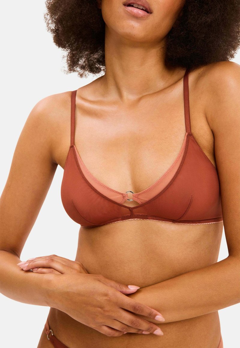 Bra in braun mit dreieckiger Form, dünnen Trägern, einem kontrastierenden helleren Band und einem silbernen Akzent in der Mitte. Glatte Textur, minimalistisches Design.
