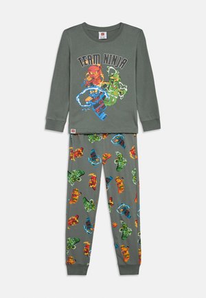 Langärmeliges graues Schlafanzugset mit einem "Team Ninja"-Aufdruck auf dem Oberteil und gemusterten Hosen, die bunte Ninja-Figuren und Wirbel zeigen.