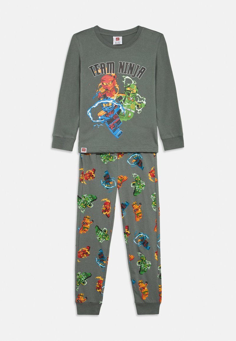 Hosszú ujjú szürke pizsama szett, amelynek tetején "Team Ninja" grafika található, és mintás nadrággal rendelkezik, színes ninja figurákkal és hullámokkal.