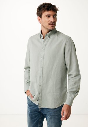 Lichtgroene knoopsluiting shirt van textuurstof, met een klassieke kraag en lange mouwen, gedragen met blauwe jeans.