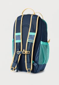 Σακίδιο πλάτης σε ναυτικό μπλε με διχτυωτές πλαϊνές τσέπες, χρυσές λεπτομέρειες και ιμάντες. Διαθέτει υφή στην επιφάνεια και ενισχυμένη κορυφαία λαβή.