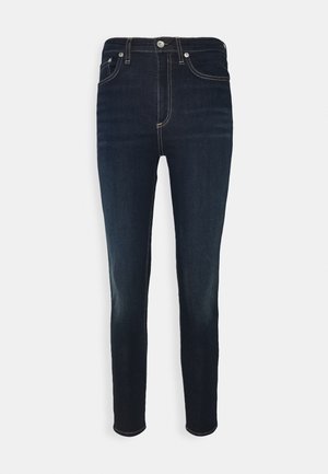 Tummansiniset denim-farkut kapealla istuvuudella, joissa on nappi- ja vetoketjusuljenta, viiden taskun malli ja kontrastitetut tikkausyksityiskohdat.