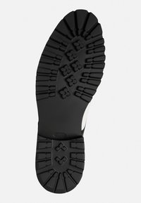 Schwarze Gummi-Schuhsohle mit ausgeprägtem Profilmuster featuring Blumendesigns und Rillen, entworfen für Haltbarkeit und Traktion.
