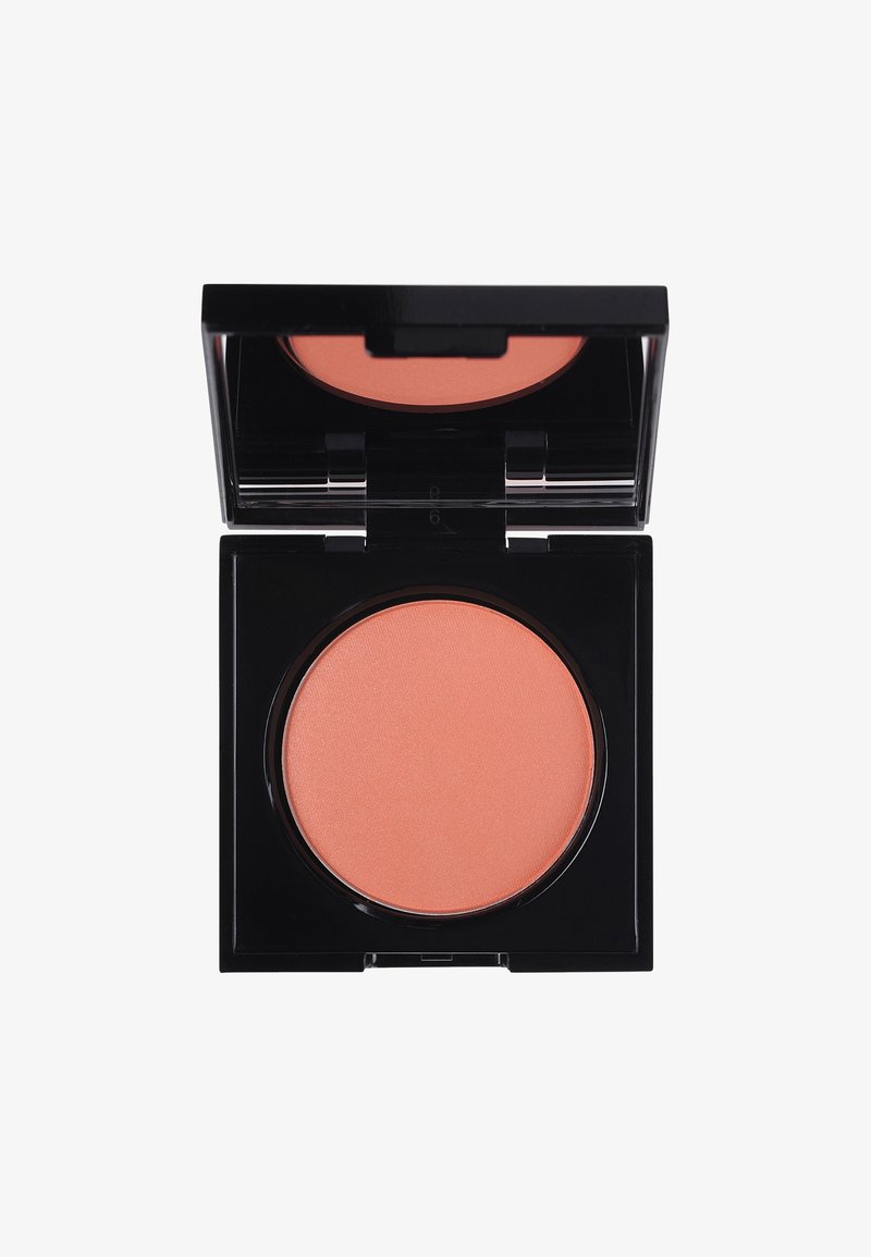 Poskipuna kompaktissa on pyöreä persikan värinen puuteriosa. Kiiltävä musta kotelo, jossa on läpinäkyvä kansi ja yksinkertainen lukitus.