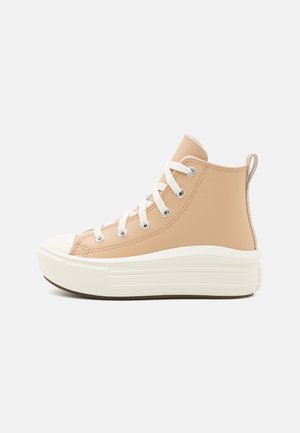 Zapatillas altas de cuero en color marrón claro con cordones blancos y puntera de goma. Presentan un acabado texturizado y una suela gruesa de color crema.