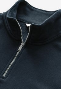 Pullover blu navy con collo alto, dotato di una chiusura a zip argentata e in un morbido tessuto testurizzato per il massimo comfort.