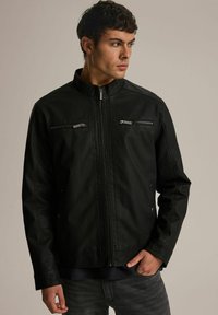 Czarna sztuczna skórzana kurtka z stójką, przednim zamkiem błyskawicznym, dwiema kieszeniami na piersi z zamkami oraz gładkim, teksturowanym wykończeniem.