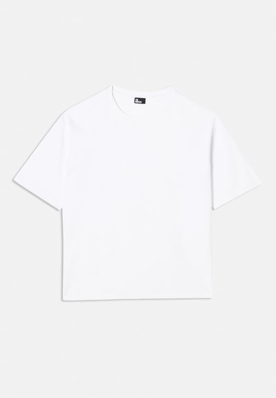 Balta trumpa rankovėmis marškinėliai, pagaminti iš medvilnės. Turi klasikį apvalų kaklą, laisvą siluetą ir jokio matomo rašto ar grafikos.