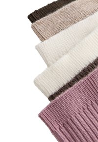 Cinq échantillons de tissu tricoté pliés en brun, beige, blanc, crème et mauve, disposés en diagonale sur un fond blanc.