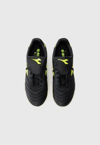 Black soccer cleats with neon yellow accents and logos, black laces, and padded tongues, viewed from above on a white background.
