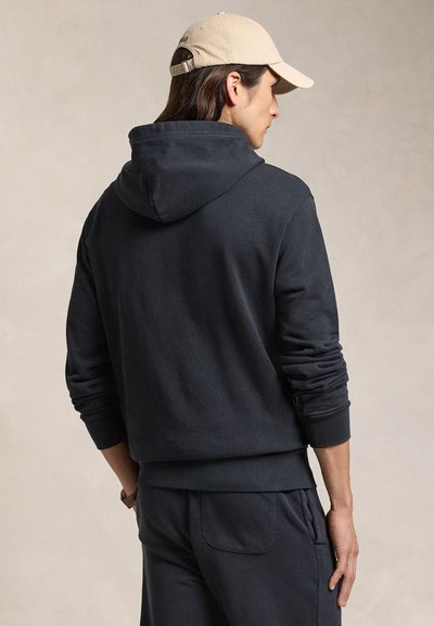 Camisola com capuz cinzento escuro, de corte descontraído e com um bolso nas costas, com capuz ajustável e punhos canelados, combinada com calças à condizer.